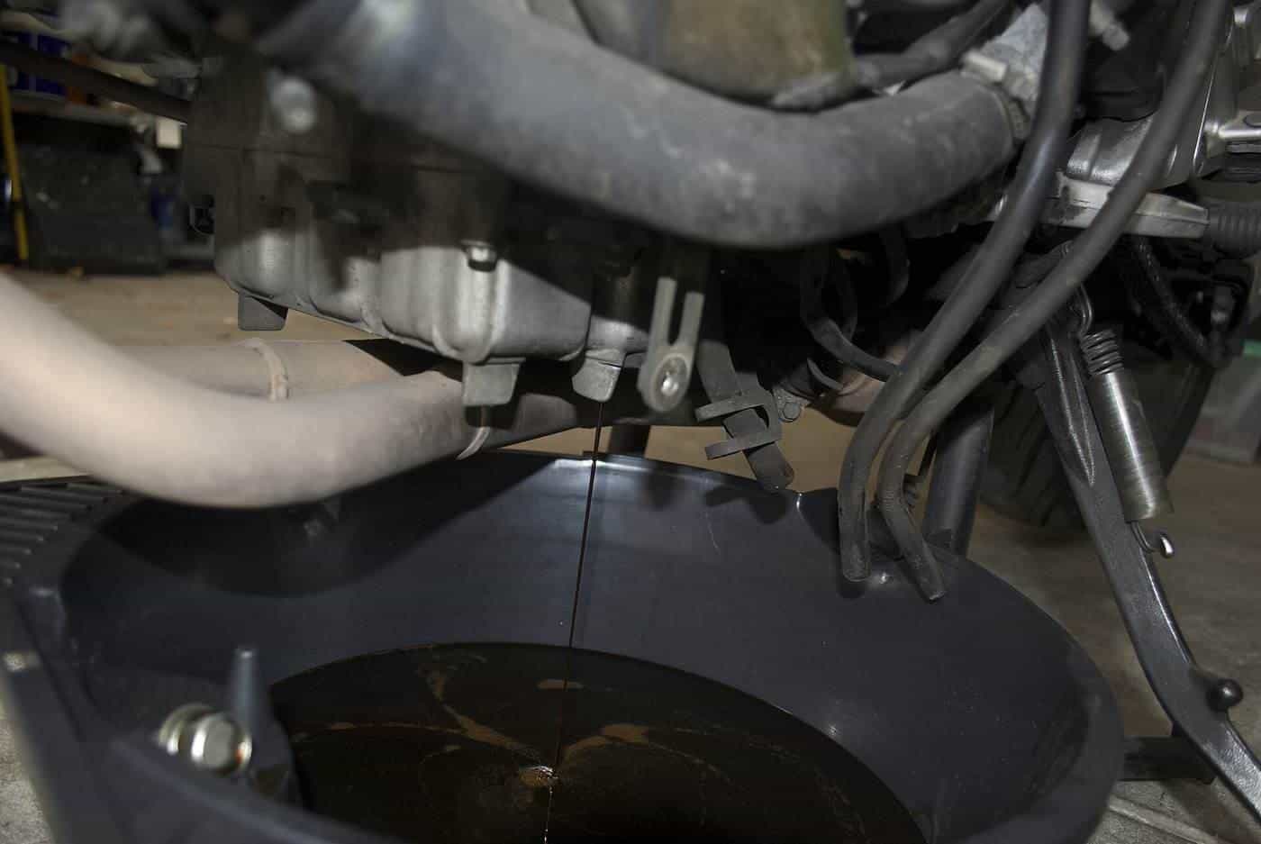 Used oil draining from a car engine into a pan