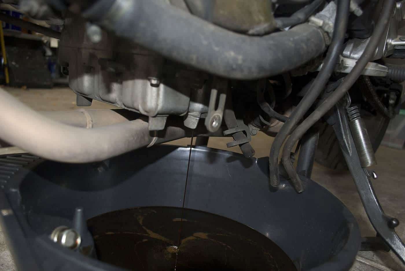 Used oil draining from a car engine into a pan