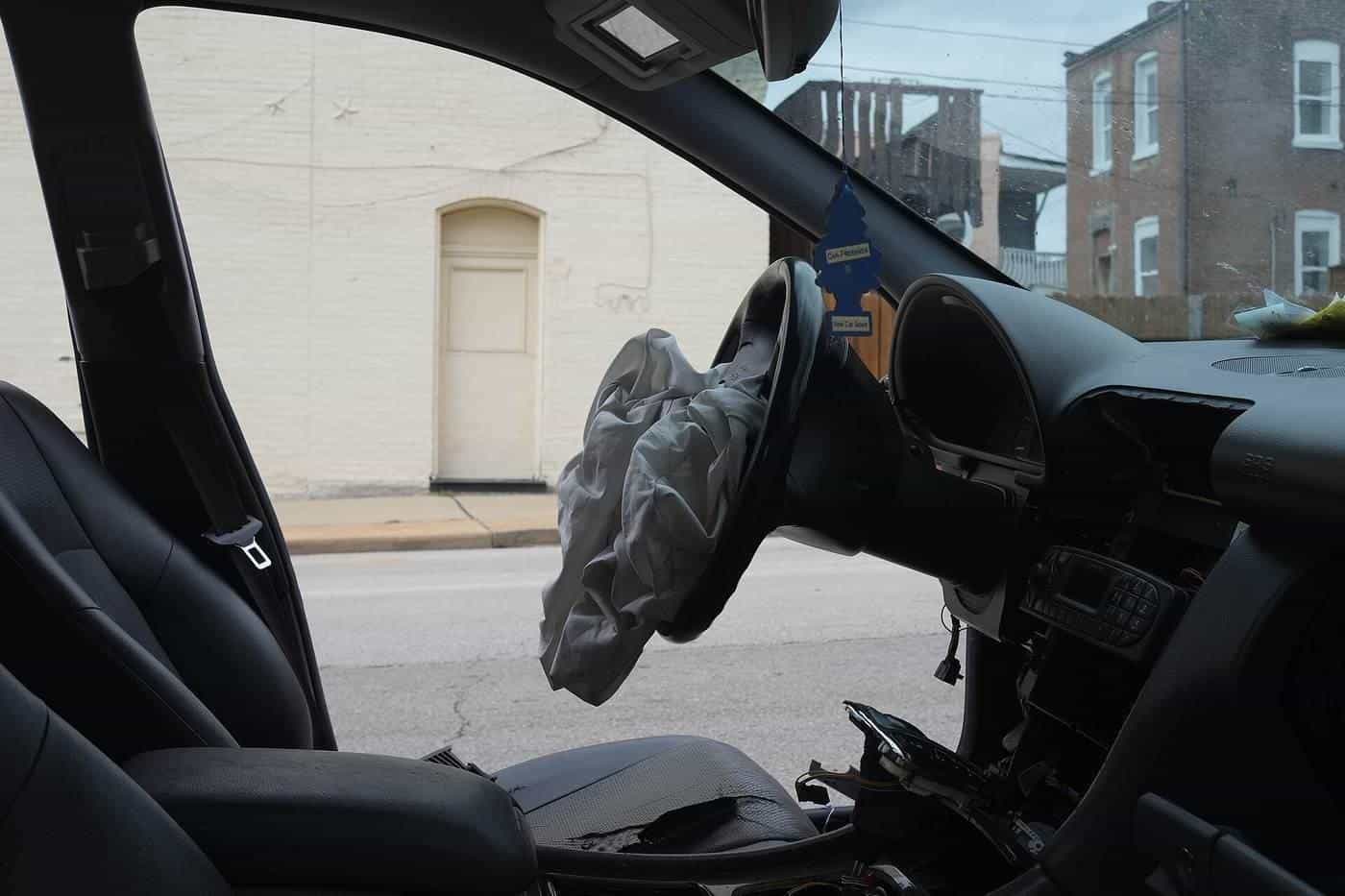 A deployed airbag hanging from a car steering wheel