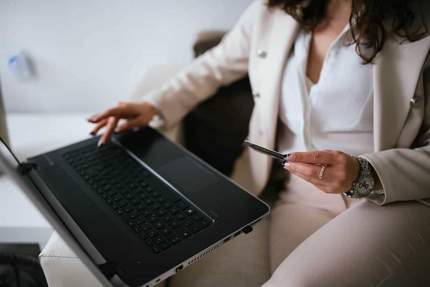 A person shopping online on a laptop with a credit card