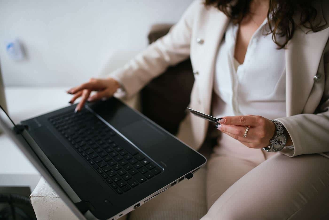 A person shopping online on a laptop with a credit card