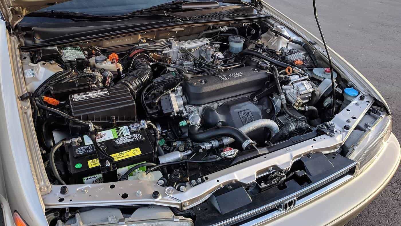 The engine bay of a 1990s sedan with the bonnet open